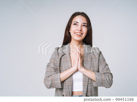 Young happy asian woman with long hair in suit on grey background Young happy asian woman with long hair in suit on grey background 99451198