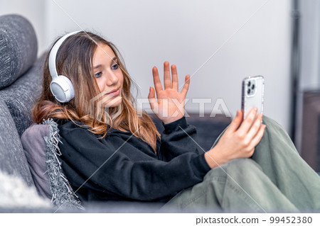 teenager communicates online at home with the help of modern technologies teenager communicates online at home with the help of modern technologies 99452380