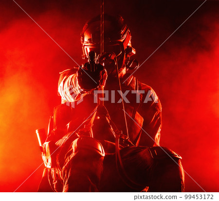 Silhouette of police officer in tactical gear descending from a height, rope exercises with weapons. Tactical rappelling, anti-terror or counter terrorism operation in darkness in rappelling harness Silhouette of police officer in tactical gear descending from a height, rope exercises with weapons. Tactical rappelling, anti-terror or counter terrorism operation in darkness in rappelling harness 99453172