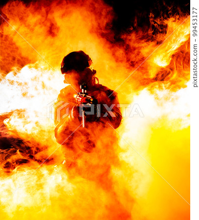 A silhouette of a soldier in fire and smoke, danger and intensity of battle. Dark outline in flames and billowing smoke, chaos and destruction of war. Respect for the sacrifices made by soldiers in 99453177