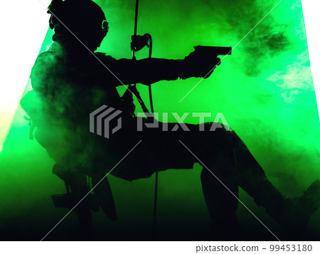 Silhouette of police officer in tactical gear descending from a height, rope exercises with weapons. Tactical rappelling, anti-terror or counter terrorism operation in darkness in rappelling harness 99453180