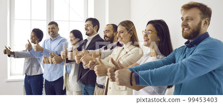 Happy diverse dream team standing in office, smiling and showing thumbs up together 99453403