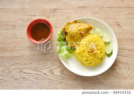 biryani rice cooked with chicken in curry on plate dipping spicy chili sauce 99454330
