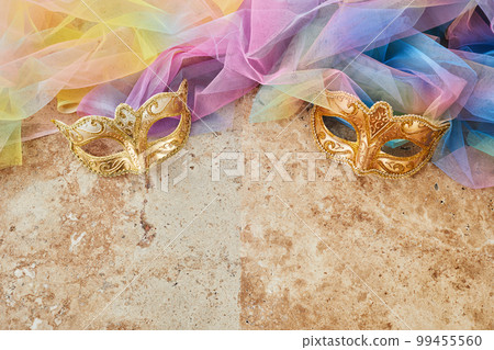 Purim celebration concept. Jewish carnival background. hamantaschen or hamans ears cookies, carnival mask and noisemaker Purim celebration concept. Jewish carnival background. hamantaschen or hamans ears cookies, carnival mask and noisemaker 99455560