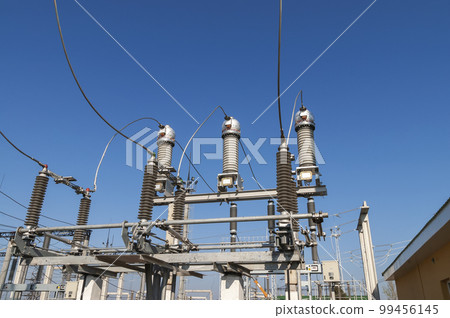 Part of high-voltage substation on blue sky background with switches and disconnectors. Ukrainian energy infrastructure. 99456145