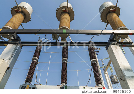 Part of high-voltage substation on blue sky background with switches and disconnectors. Ukrainian energy infrastructure. Part of high-voltage substation on blue sky background with switches and disconnectors. Ukrainian energy infrastructure. 99456160
