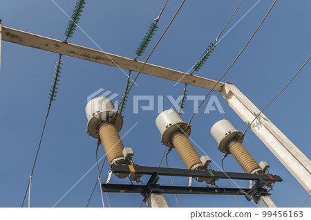 Part of high-voltage substation on blue sky background with switches and disconnectors. Ukrainian energy infrastructure. Part of high-voltage substation on blue sky background with switches and disconnectors. Ukrainian energy infrastructure. 99456163