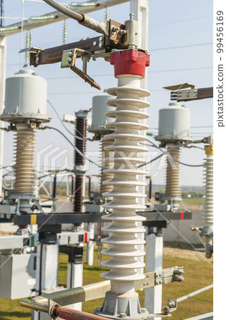 Part of high-voltage substation on blue sky background with switches and disconnectors. Ukrainian energy infrastructure. 99456169
