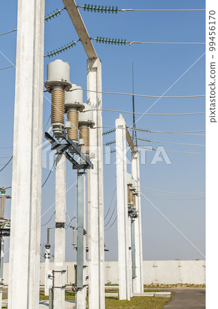 Part of high-voltage substation on blue sky background with switches and disconnectors. Ukrainian energy infrastructure. Part of high-voltage substation on blue sky background with switches and disconnectors. Ukrainian energy infrastructure. 99456170