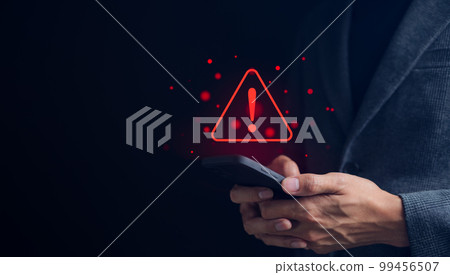 Businessman or User holding smartphone with triangle caution warning sign red for notification error and maintenance concept. warning sign exclamation, Businessman or User holding smartphone with triangle caution warning sign red for notification error and maintenance concept. warning sign exclamation, 99456507