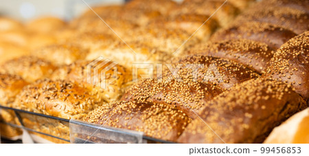 fresh golden breads on the shelf of the bread section of the supermarket 99456853