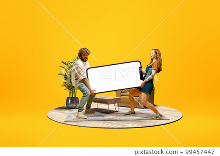 Young man and girl carrying giant 3D model of mobile phone with empty screen for text, ad. Online shopping. Mockup for design, logo. Young man and girl carrying giant 3D model of mobile phone with empty screen for text, ad. Online shopping. Mockup for design, logo. 99457447