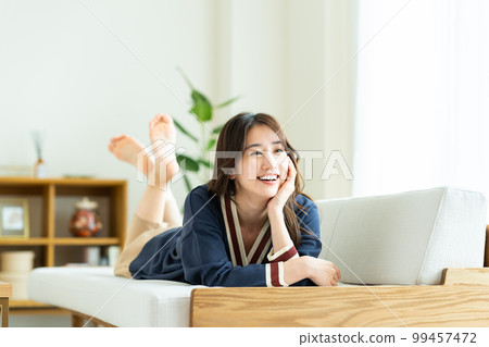 年輕女子在客廳放鬆 年輕女子在客廳放鬆 99457472