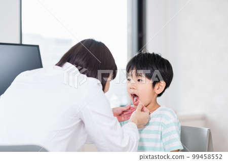 A boy being examined by a female doctor 99458552