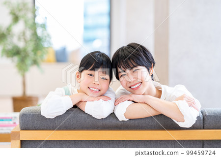 Parents and children relaxing on the sofa. 99459724