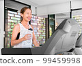 young happy asian woman athlete run on treadmill, running machine, in indoor gym fitness for health; 99459998