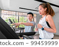 young happy asian woman athlete run on treadmill, running machine, in indoor gym fitness for health; 99459999