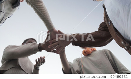 a group of faceless Friends stacking their hands together a group of faceless Friends stacking their hands together 99460381