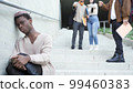 Classmates bullying sad black transgender man on stairs 99460383