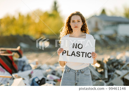 A young woman holds a poster. The inscription NO PLASTIC. Showing a sign protesting against plastic pollution. 99461146