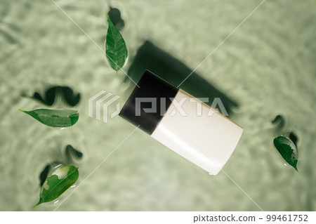 Fashion trendy bottle of perfume toilet water with leaves, lotion on green wave splash background. Beauty product Fashion trendy bottle of perfume toilet water with leaves, lotion on green wave splash background. Beauty product 99461752