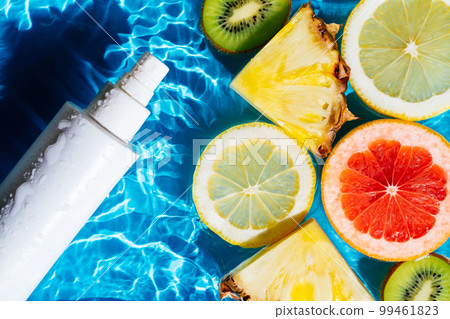 White beauty product sunscreen cream vial sprayer in transparent fresh water with flecks and waves, friut citrus. White beauty product sunscreen cream vial sprayer in transparent fresh water with flecks and waves, friut citrus. 99461823