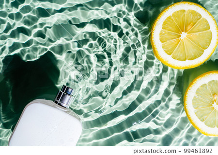 White square perfume bottle on green blue transparent reflect rippled wave water surface, copy space, lemon citrus slice 99461892
