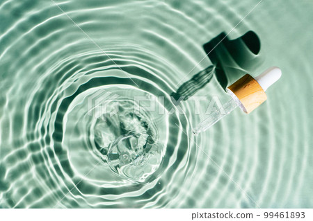 Facial pipette serum, essence cosmetic product in water drop splashing fresh transparent, flecks. Flat lay, top view. 99461893