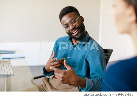 Positive african american businessman explaining new responsibilities to female applicant 99462483