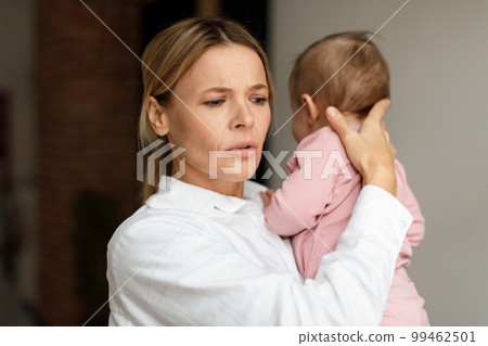 Maternity concept. Worried mother holding her baby on hands, kid crying or feeling scared, woman conforting him Maternity concept. Worried mother holding her baby on hands, kid crying or feeling scared, woman conforting him 99462501