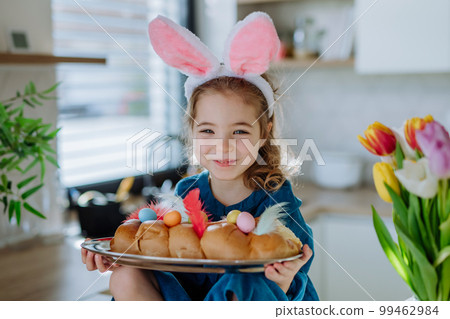 Little girl holding easter pastries, celebrating easter and spring. 99462984