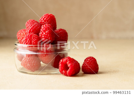 Fresh Raspberry in glass bowl, warm neutral background. Copy space Fresh Raspberry in glass bowl, warm neutral background. Copy space 99463131