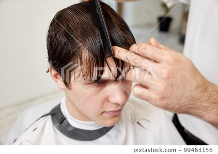Barber talking to caucasian man while sitting in chair Barber talking to caucasian man while sitting in chair 99463156