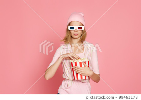 pretty blonde girl holding bucket of popcorn pretty blonde girl holding bucket of popcorn 99463178