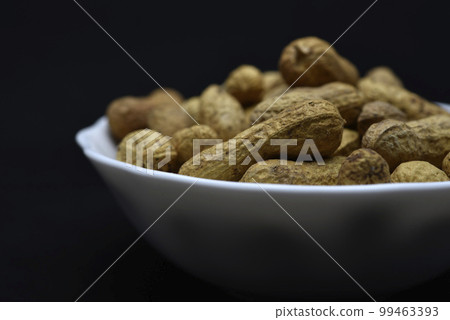 Groundnut. Unpeeled peanuts in a white plate. Peanuts in the peel. Groundnut. Unpeeled peanuts in a white plate. Peanuts in the peel. 99463393