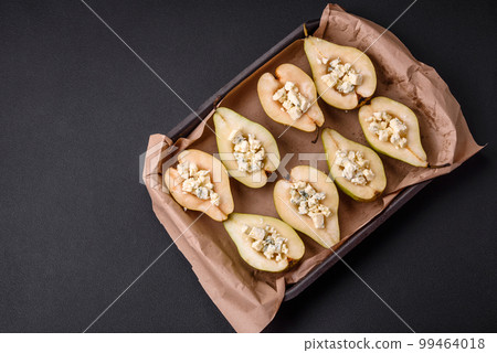 Delicious baked pear with dorblu cheese, walnut and honey on a textured concrete background 99464018