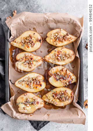 Delicious baked pear with dorblu cheese, walnut and honey on a textured concrete background 99464032