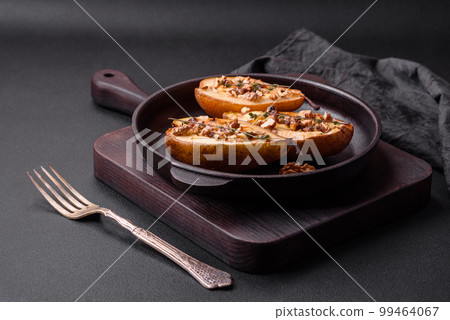 Delicious baked pear with dorblu cheese, walnut and honey on a textured concrete background 99464067