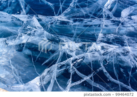 Many beautiful cracks in the clear blue ice. Layered thick ice. Horizontal. Many beautiful cracks in the clear blue ice. Layered thick ice. Horizontal. 99464072