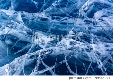 Natural texture of transparent clear ice of a lake with cracks. Many cracks in thick ice. Horizontal. 99464074