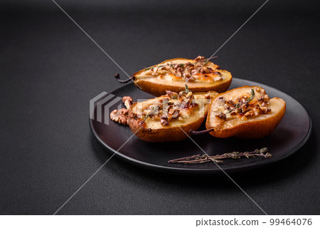 Delicious baked pear with dorblu cheese, walnut and honey on a textured concrete background Delicious baked pear with dorblu cheese, walnut and honey on a textured concrete background 99464076