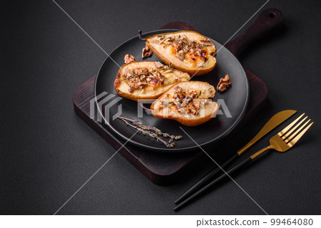 Delicious baked pear with dorblu cheese, walnut and honey on a textured concrete background 99464080