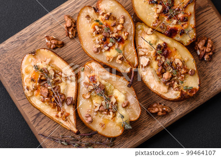 Delicious baked pear with dorblu cheese, walnut and honey on a textured concrete background 99464107