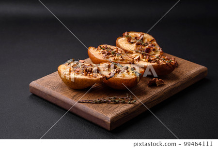 Delicious baked pear with dorblu cheese, walnut and honey on a textured concrete background 99464111