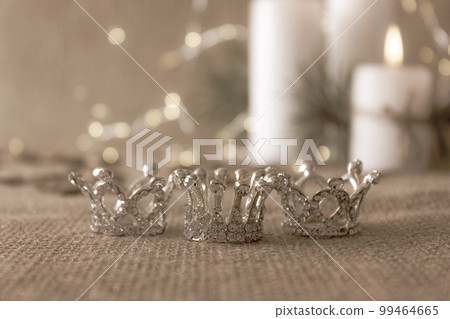 Three silver crowns, symbol of Tres Reyes Magos (Three Wise Men) on beige bokeh background. Three silver crowns, symbol of Tres Reyes Magos (Three Wise Men) on beige bokeh background. 99464665