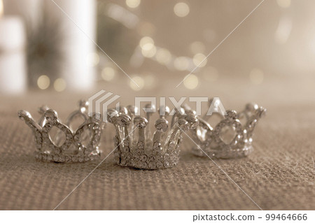 Three silver crowns, symbol of Tres Reyes Magos (Three Wise Men) on beige bokeh background. Three silver crowns, symbol of Tres Reyes Magos (Three Wise Men) on beige bokeh background. 99464666