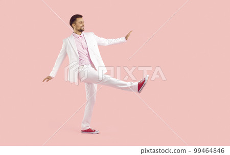 Full length shot of funny man in white suit walking against pink color background Full length shot of funny man in white suit walking against pink color background 99464846