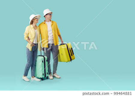 Cheerful young Caucasian man and woman with big tourist suitcases smiling go on summer trip Cheerful young Caucasian man and woman with big tourist suitcases smiling go on summer trip 99464881