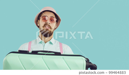 Funny traveler with suitcase feels skeptical about something during summer holiday trip Funny traveler with suitcase feels skeptical about something during summer holiday trip 99464883