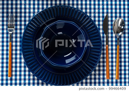 Deep blue ceramic plate with cutlery close up Deep blue ceramic plate with cutlery close up 99466409
